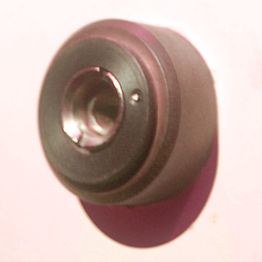 Metallisches Objekt mit zylindrischer Form vor rosa Hintergrund.
