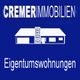 Logo von Cremer Immobilien, weiße Wohnungsgrafik und Text auf blauem Hintergrund.