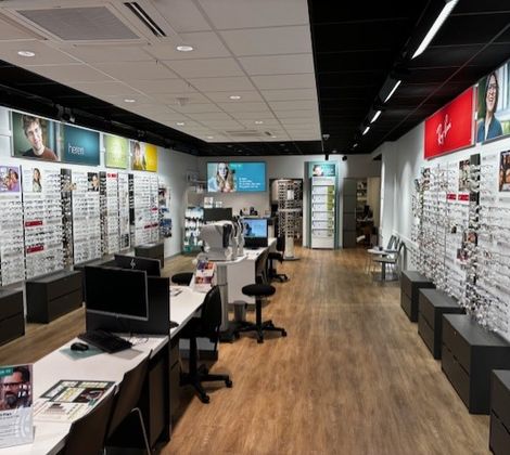 Een brillenwinkel met vitrines vol brillen en enkele bureaus voor klantenservice.