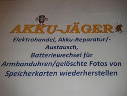 "Werbeschild von Akku-Jäger mit Dienstleistungen wie Akku-Reparatur und Fotos wiederherstellen."