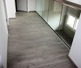 Flur mit Holzboden, weißer Wand und Spiegelwand, offenes Fenster sichtbar.