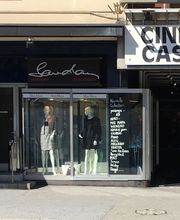 Geschäft mit Schaufensterpuppen neben einem Kinoeingang mit Schild "CINEMA CASINO".