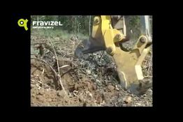 Excavadora removiendo tierra en un área forestal, marca Fravizel visible en la esquina superior.