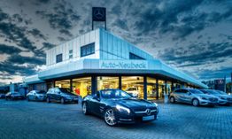 Autohandel mit mehreren Mercedes-Fahrzeugen im Freien bei bewölktem Himmel in der Dämmerung.