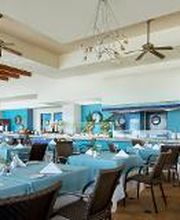 Restaurante elegante con mesas azules y decoración marina en las paredes.