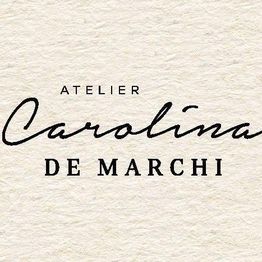 Logotipo com o texto "Atelier Carolina de Marchi" em fundo bege.