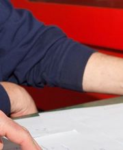 Zwei Personen prüfen gemeinsam Dokumente auf einem Tisch.