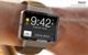 Smartwatch an Handgelenk, zeigt Uhrzeit 9:42 und "slide to unlock" am 2. Mai 2010.