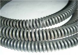 Tubos corrugados pretos enrolados sob superfície branca.