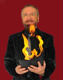 Ein Mann im Anzug hält ein brennendes Buch vor einem tiefroten Hintergrund.