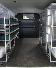 Transporter-Innenraum mit Regalen und Schubladen für Werkzeug und Material organisiert.