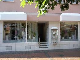 Kosmetikgeschäft mit breiter Fensterfront und Beschriftung "Kosmetik-Oase Petereck" in einer Straße.