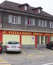 Eckrestaurant mit Pizzeria und Kebap, drei geparkte Autos davor, gelbes und rotes Design.