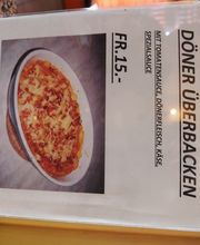 Bild eines Menüs mit überbackenem Döner für 15 Franken, mit Tomatensauce, Fleisch und Käse.