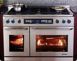 Stainless steel stove with double ovens in use, and pots on the burners.