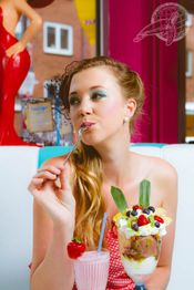 Frau genießt Eisbecher und Milchshake in Retro-Diner.