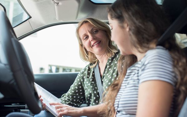 Fahrlehrerin erklärt Schülerin Auto fahren