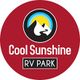 Red circular logo for Cool Sunshine RV Park with mountain and sun design.