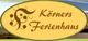 Gelbes Oval mit braunem Text "Körners Ferienhaus" und dekorativem Element links.