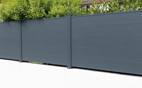 WPC Sichtschutz-Zaun an einer Grundstücksgrenze in anthrazitfarben.