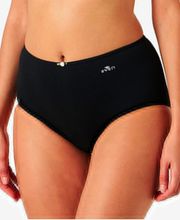 Modelo femenina lleva braga negra de talle alto con pequeño detalle decorativo.