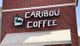 Caribou Coffee sign on a brick wall with a canopy below.