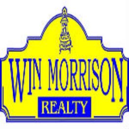 Yellow and blue sign reads "Win Morrison Realty," featuring a small tower illustration.