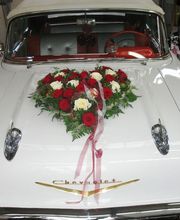 Oldtimer mit Blumengesteck in Herzform auf der Motorhaube.