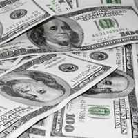 A pile of one hundred US dollar bills scattered randomly.