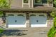 Double garage doors with windows and stone wall exterior in a residential setting.