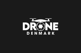 Logo med ordet "DRONE" med en drone grafik, "DENMARK" nedenunder. Sort baggrund.