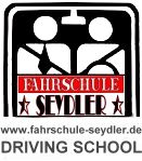 Logo der Fahrschule Seydler, zwei stilisierte Figuren im Auto, Text "DRIVING SCHOOL".