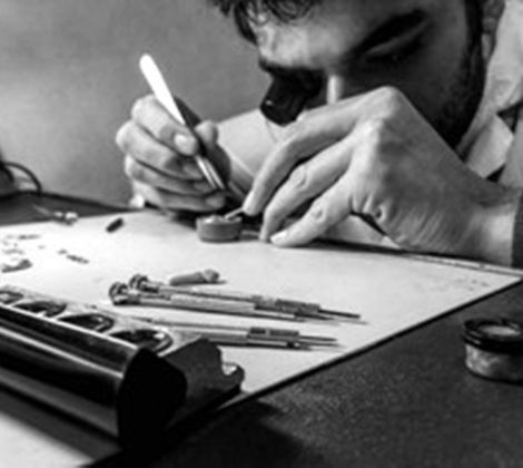 Orologiaio al lavoro con strumenti di precisione.