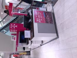 Ein kleiner Verkaufsstand mit Telekom-Werbung in einem Einkaufszentrum.