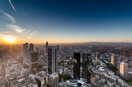 Sonnenuntergang über der Skyline von Frankfurt mit hohen Wolkenkratzern und klarem Himmel.