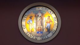 Great Seal of Wyoming displayed on a wall, depicting figures and the motto "Equal Rights."