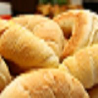 Blurred image of freshly baked croissants on a tray.
