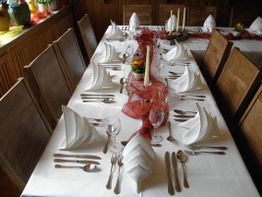 Elegant gedeckter Tisch mit gefalteten Servietten und Kerzen in der Mitte.