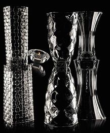 Drei verzierte Glasvasen auf schwarzem Hintergrund, fast transparent und spiegelnd.