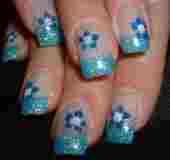 Blaue Blumen-Nageldesigns auf Fingernägeln mit Glitzer detailliert verziert.