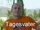 Ein Mann mit orangefarbenem T-Shirt vor einer grünen Landschaft, darüber steht "Tagesvater".