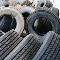 A stack of old tires, some with worn treads, piled haphazardly in an outdoor setting.