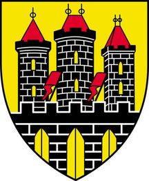 Wappen mit drei schwarzen Türmen auf gelbem Hintergrund. Rote Dächer und vier rote Flaggen.