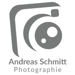 Graues Kameralogo von Andreas Schmitt Fotografie auf weißem Hintergrund.