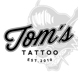 Logo von Tom's Tattoo, est. 2010, mit stilisiertem Wolf im Hintergrund.