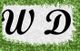 Schwarze Buchstaben "W D" auf weißem Hintergrund, umrahmt von grünen Blättern.