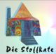 Buntes Haus mit kreativem Design, darunter steht "Die Stoffkate" geschrieben.
