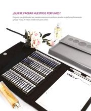 Mostrario de perfumes, flores, bloc de notas y bolígrafos sobre una superficie blanca.