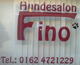 Text auf Glasscheibe: Hundesalon Fino, Tel.: 0162 4721229, rote Schrift, Pfotenabdruck.