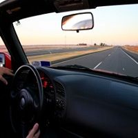 Driving down an empty highway at sunset, view from inside the car.